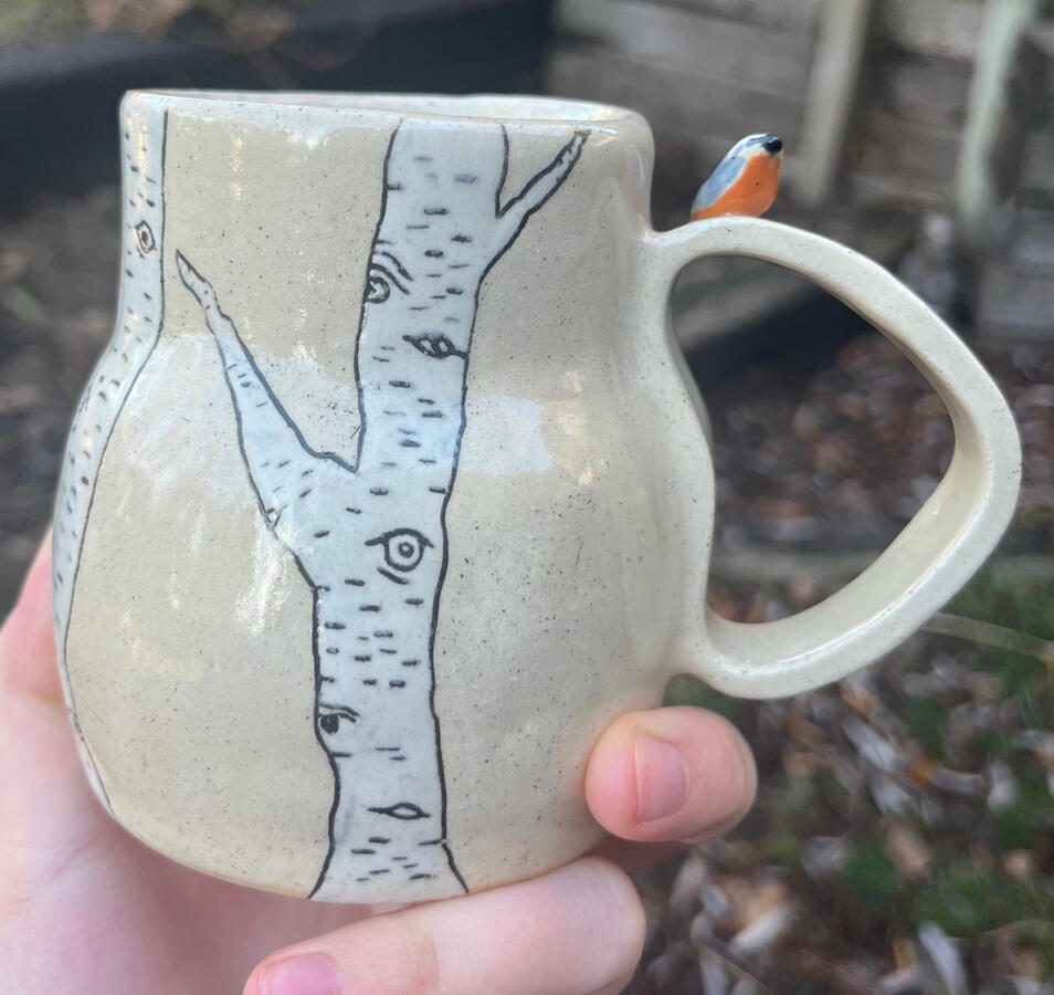 Short birch tree and nuthatch mug (underglaze, slip inlay, handle buddy) - $45
